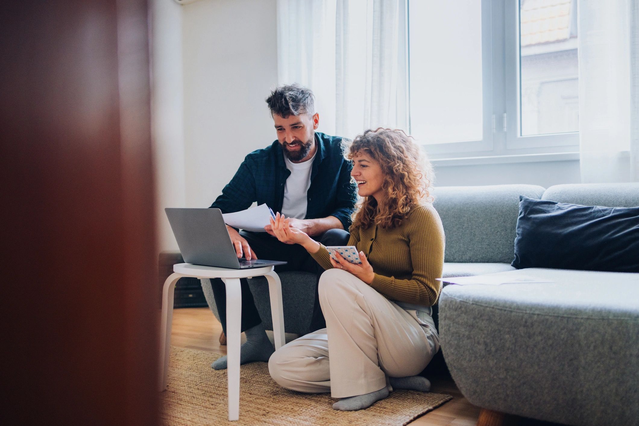 Couple reviewing home loan documents and budget on a laptop at home